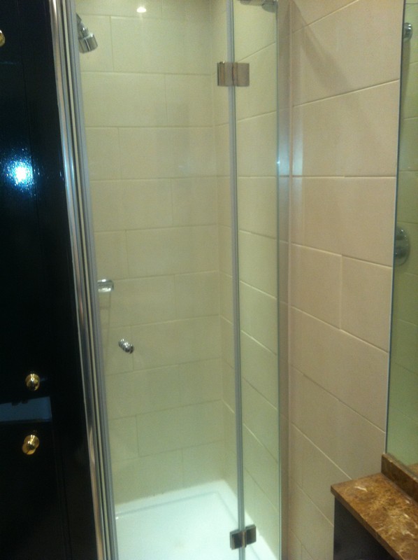 Frameless glass shower enclosure with chrome fittings in South Lambeth